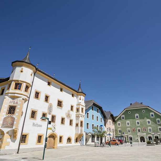 Colorful European buildings with unique architecture under a clear blue sky, featuring white, blue, and green facades with steep roofs.