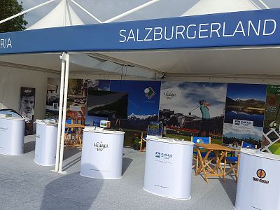 Tourism booth for Salzburgerland at exhibition with scenic images and informational displays.