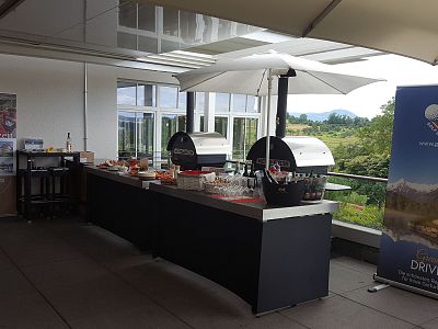 An outdoor buffet setup with covered tables and scenic background, suitable for events.