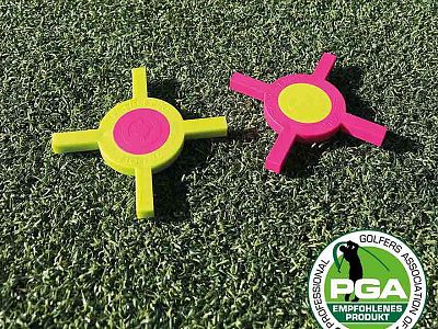 Two colorful golf training tools on artificial turf beside PGA of Germany logo, showing endorsement. One is lime green, the other pink.