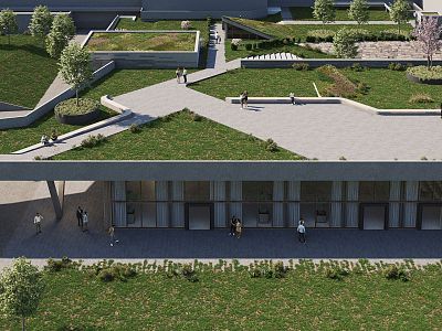 Aerial view of a modern building with a green roof and rooftop gardens. People walk along paths, surrounded by landscaped lawns and trees.