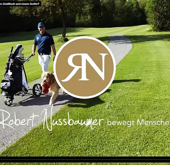 A person with a golf cart and a dog on a golf course, surrounded by greenery and trees.