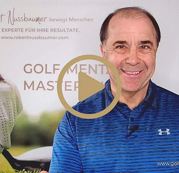 Ein Mann in blauem Hemd lächelt in die Kamera. Im Hintergrund ist ein Plakat mit Text über Golfmentoring zu sehen. Es wirkt wie ein Videovorschaubild.