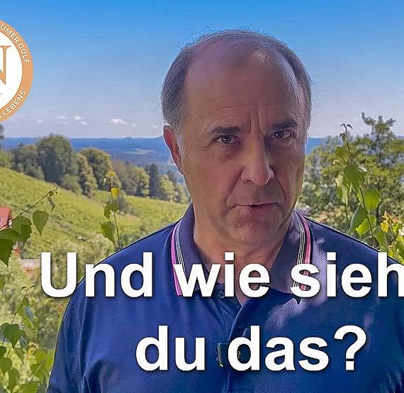 A man stands outdoors with a scenic backdrop of rolling hills and a clear blue sky, wearing a blue polo shirt. Text overlay reads 'Und wie siehst du das?'.