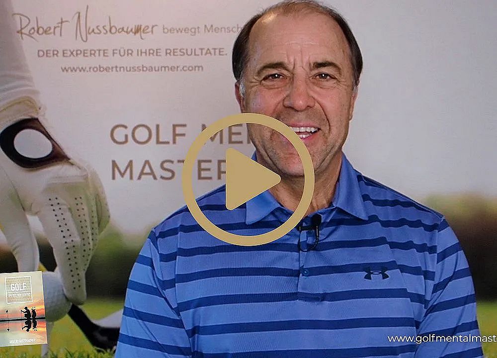 Man in a blue shirt smiling in front of a golf-themed advertisement with a play button overlay.