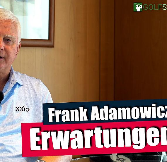 Ein Mann mittleren Alters sitzt vor einer Holzwand, trägt ein hellblaues Poloshirt und hat ein Mikrofon am Kragen. Der Text "Frank Adamowicz Erwartungen" ist eingeblendet.