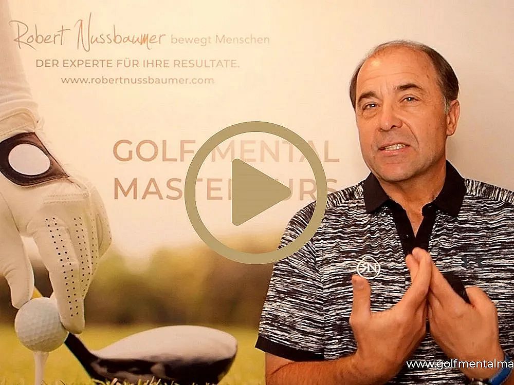 Ein Mann spricht vor einem Plakat, das "Golf Mental Mastery" bewirbt. Er trägt ein gestreiftes Poloshirt und gestikuliert mit den Händen beim Sprechen.