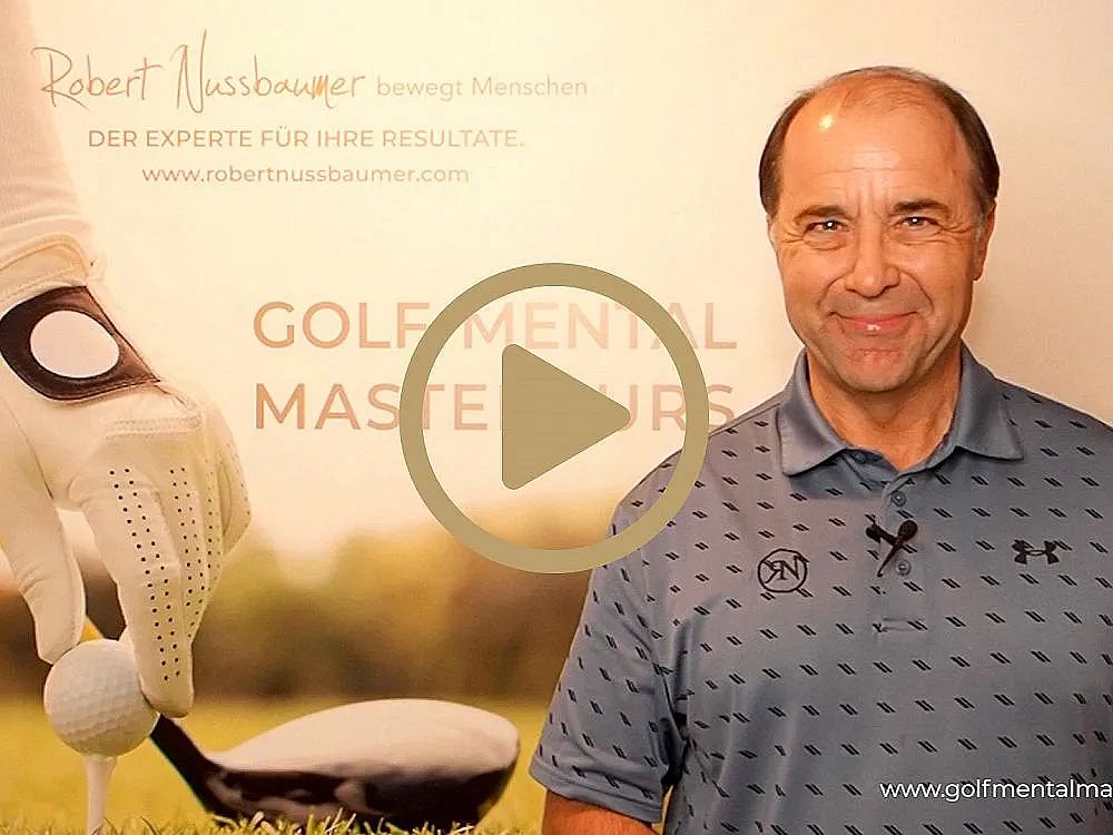 Man stands beside a banner promoting a golf mental mastery course, featuring a gloved hand placing a golf ball on a tee.