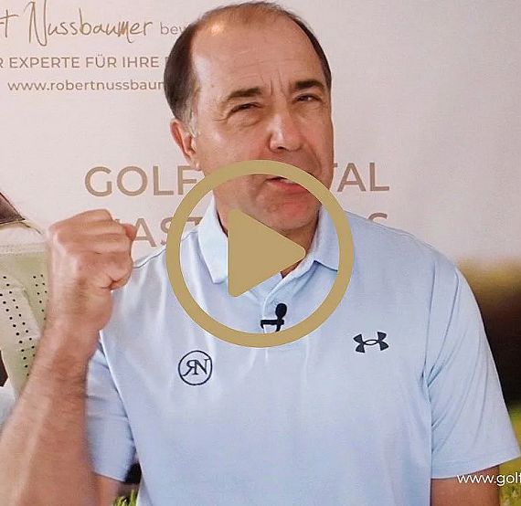 Mann in hellblauem Polohemd spricht energisch, hebt die geballte Faust. Hintergrund zeigt Werbebanner mit Golfbezug. Mann ist nicht identifizierbar.
