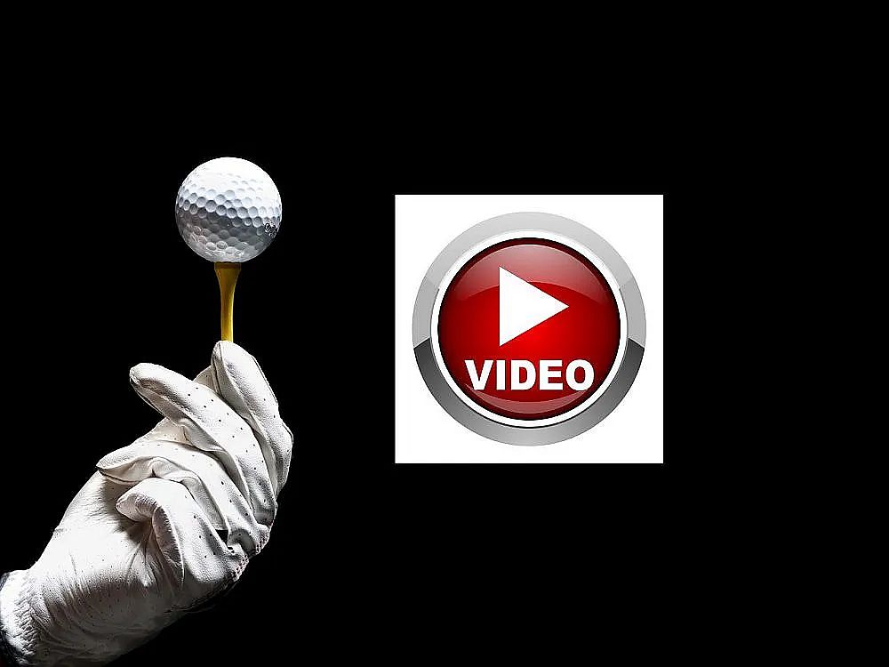 A gloved hand holds a golf ball on a tee against a black background, beside a red play button with the word 'VIDEO'. Perfect for golf tutorials.