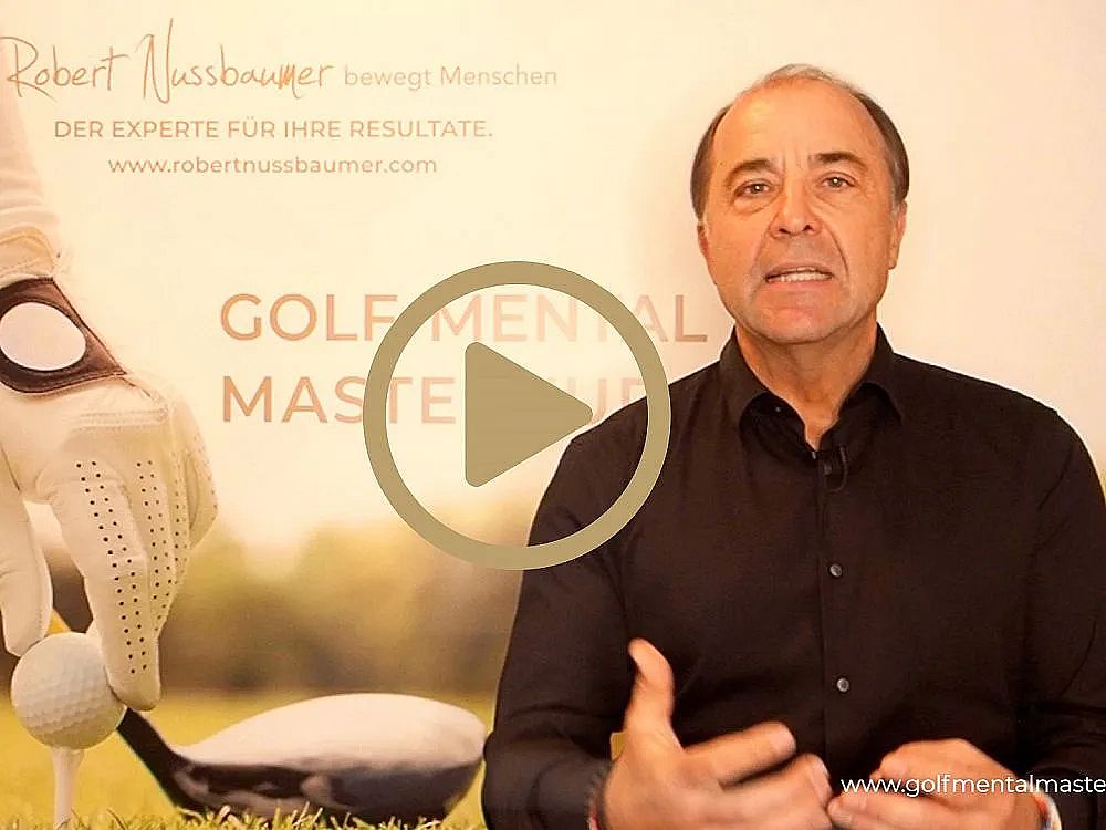 A man in a black shirt speaks in front of a banner about golf mental mastery. A golfer's gloved hand and a golf ball are visible.