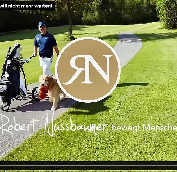 A golfer pulling a golf cart along a green path accompanied by a golden retriever. Sunny day, lush greenery, and a sense of leisure and outdoor activity.