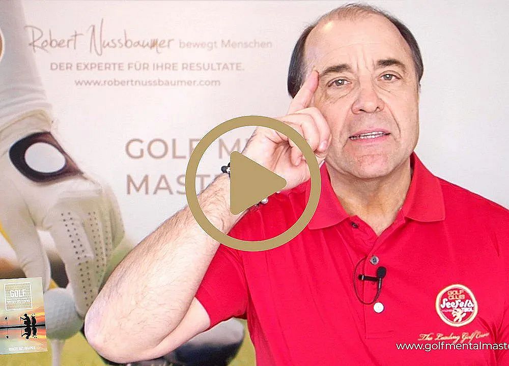 Ein Mann in einem roten Polohemd gestikuliert mit der Hand an der Stirn, während er in die Kamera spricht. Im Hintergrund ist Werbung für Golf zu sehen.