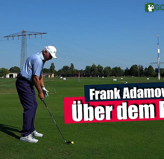 Golfer in blue attire prepares to swing on a vast green golf course. A banner reads 'Frank Adamowicz Über dem Ball' against the open sky backdrop.