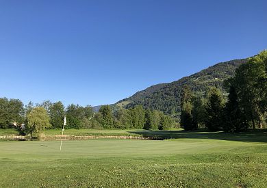 Wie geht man vor, wenn der Ball wegen des Windes zwischen Flaggenstock und Lochrand eingeklemmt wird und zur Hälfte über den Lochrand ragt?